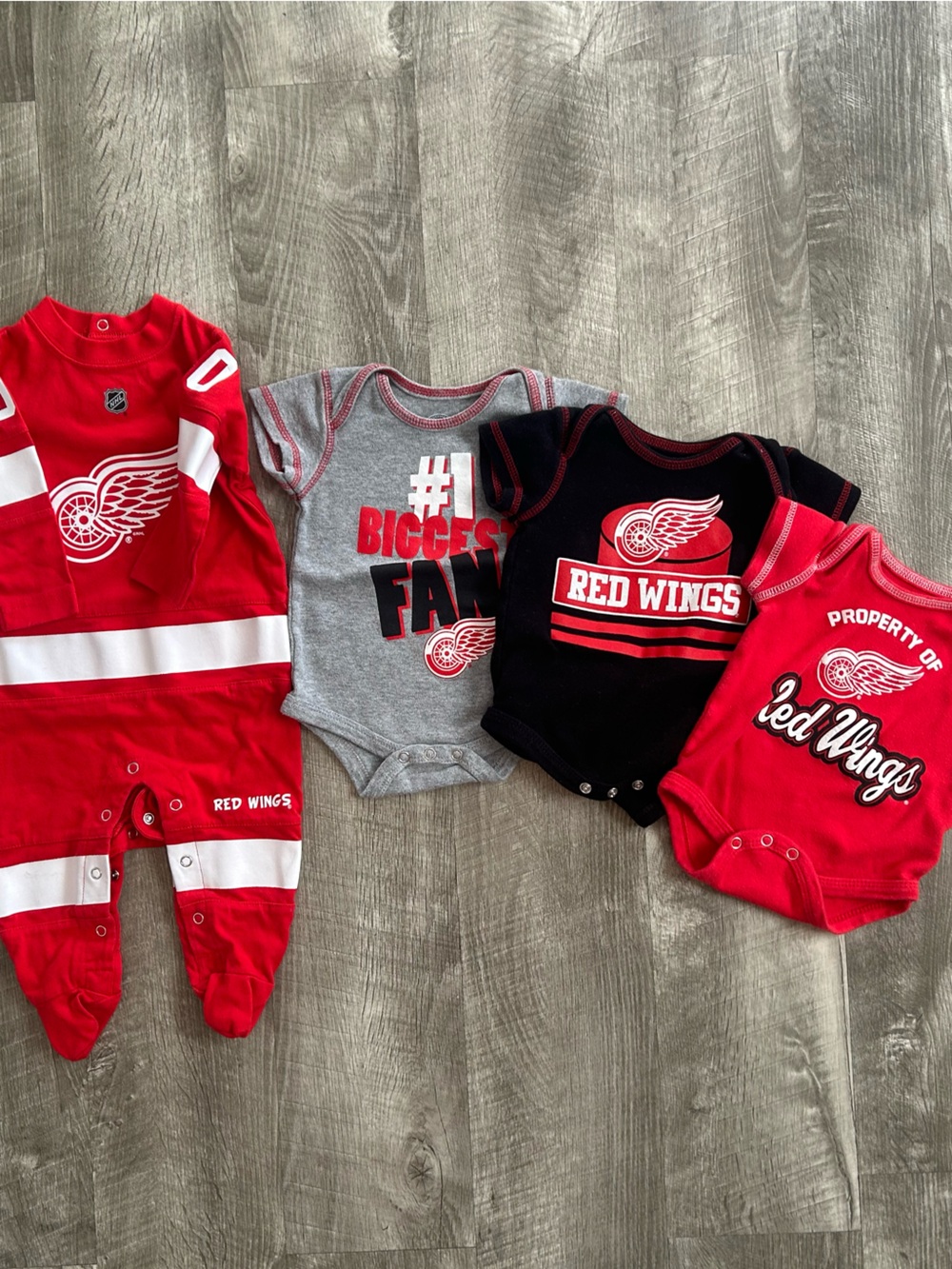 Detroit Red Wings Baby Bodysuit Set - 1 footie, 3 onesies.